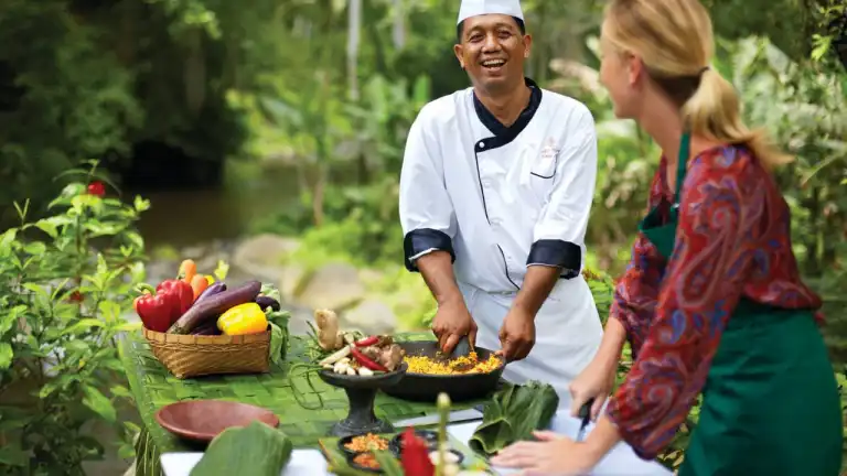 Chef preparing tropical vegetables outdoors in Bali garden cooking class