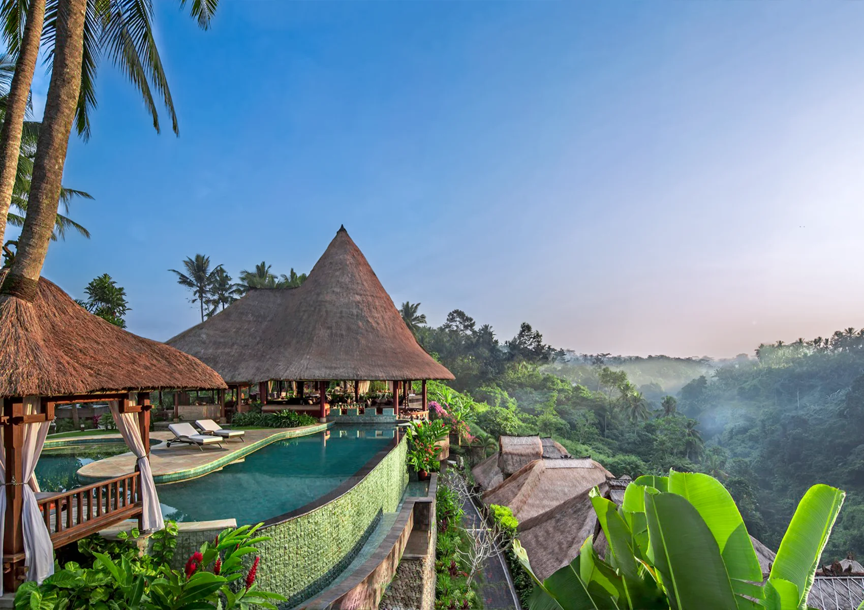 Viceroy Bali main infinity pool overlooking the lush jungle valley in Ubud, featuring luxury cabanas, tropical gardens, and a secluded honeymoon resort atmosphere in the Valley of the Kings