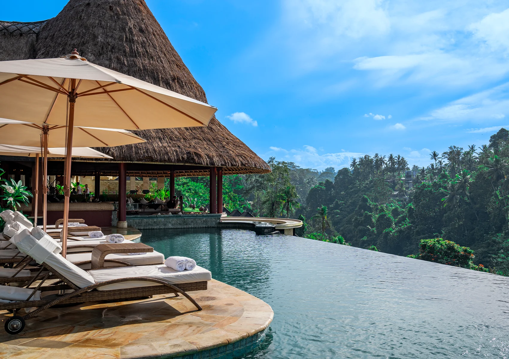 Luxury infinity pool at Viceroy Bali overlooking the lush jungle valley in Ubud with elegant poolside loungers, tropical scenery, and a secluded honeymoon resort atmosphere in Bali